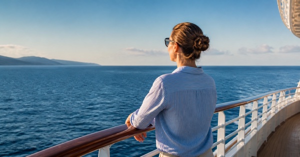 Passagère regardant l'horizon depuis le pont d'un paquebot par mer calme